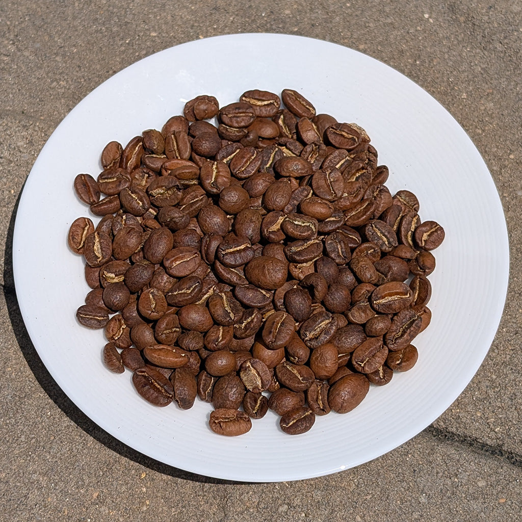 Coffee beans on a white plate with a brown background
