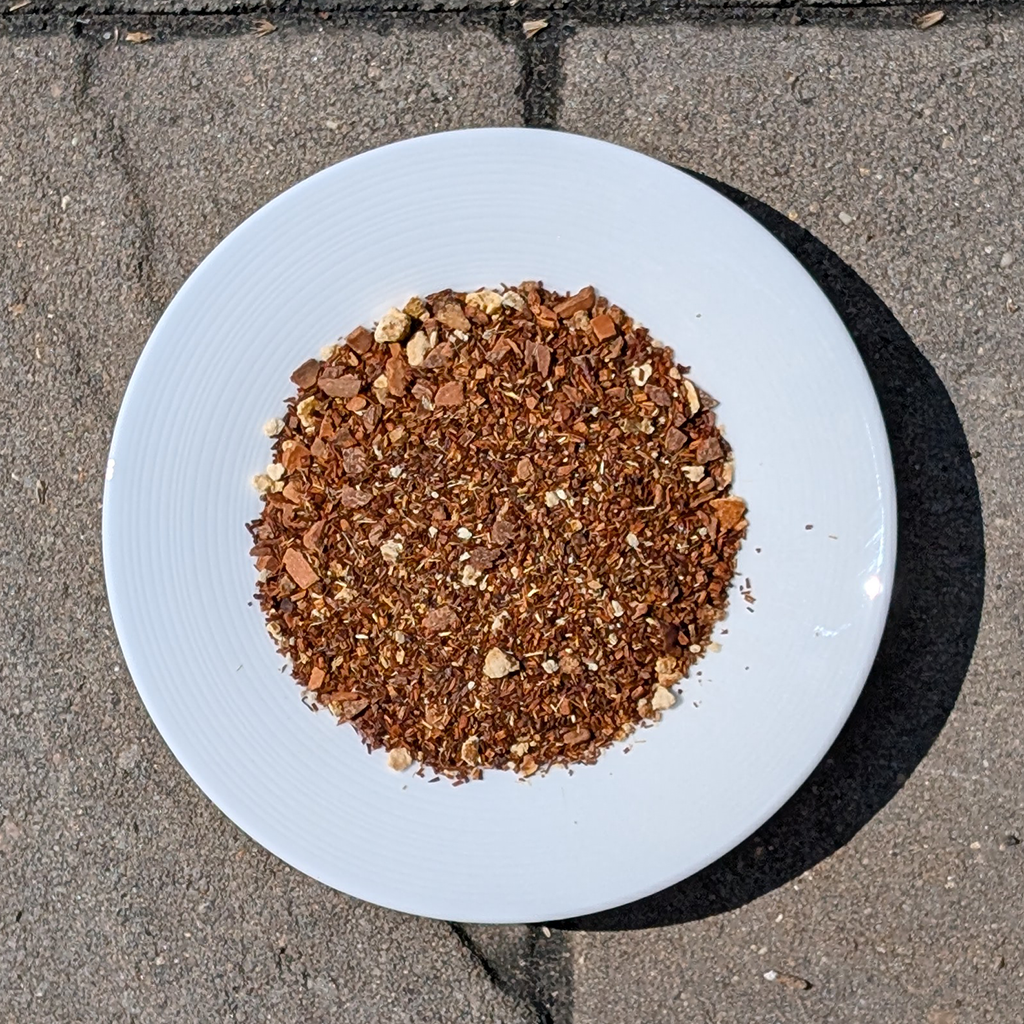 White plate with a small amount of brown powder on a concrete surface