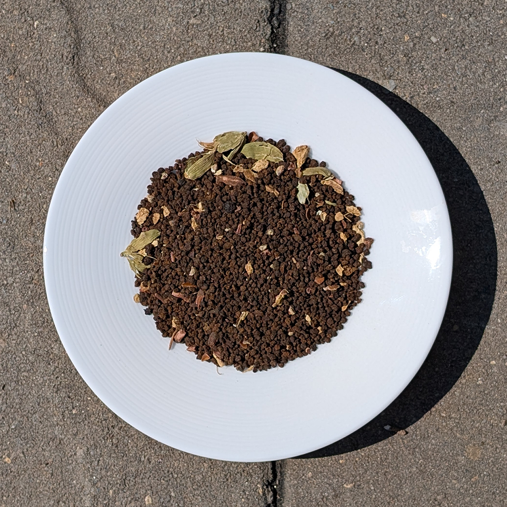 White plate with loose leaf tea on a concrete surface